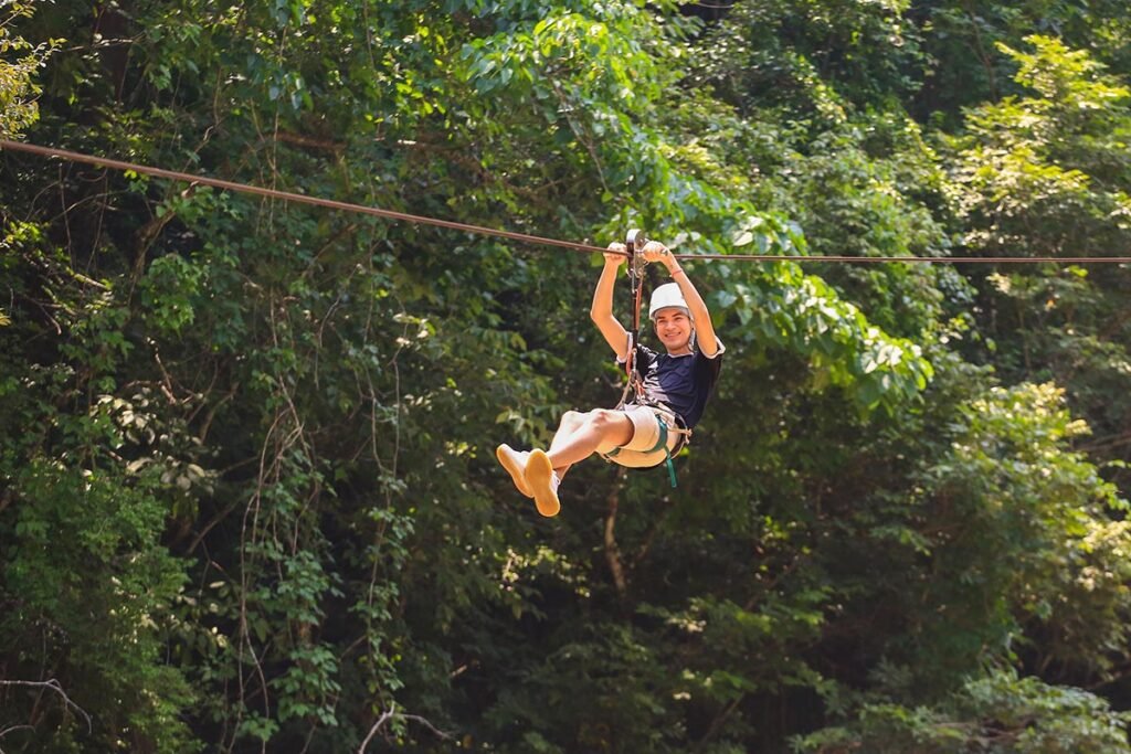 Jorullo Bridge ATV Zip Line 11 Tirolesas 3 Hombre sonriendo mientras vuela libremente en las divertidas tirolesas en Puerto Vallarta sobre la selva.