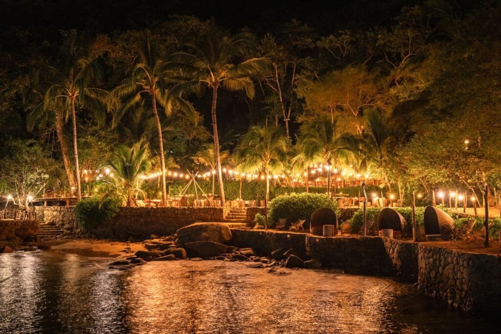 Vista nocturna del montaje Premier iluminado con velas.