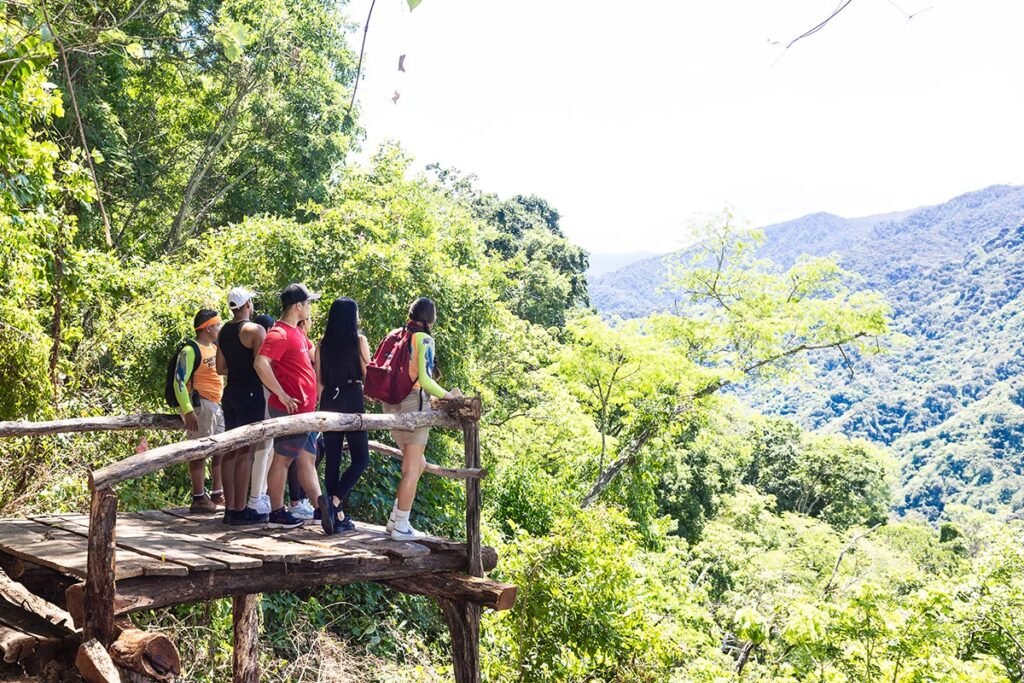 Jorullo Point ATV Mirador de Cristal: Aventura Extrema en Vallarta 4 Grupo de aventureros sonriendo triunfantes frente al Mirador de Cristal Jorullo Point tras finalizar su recorrido guiado.