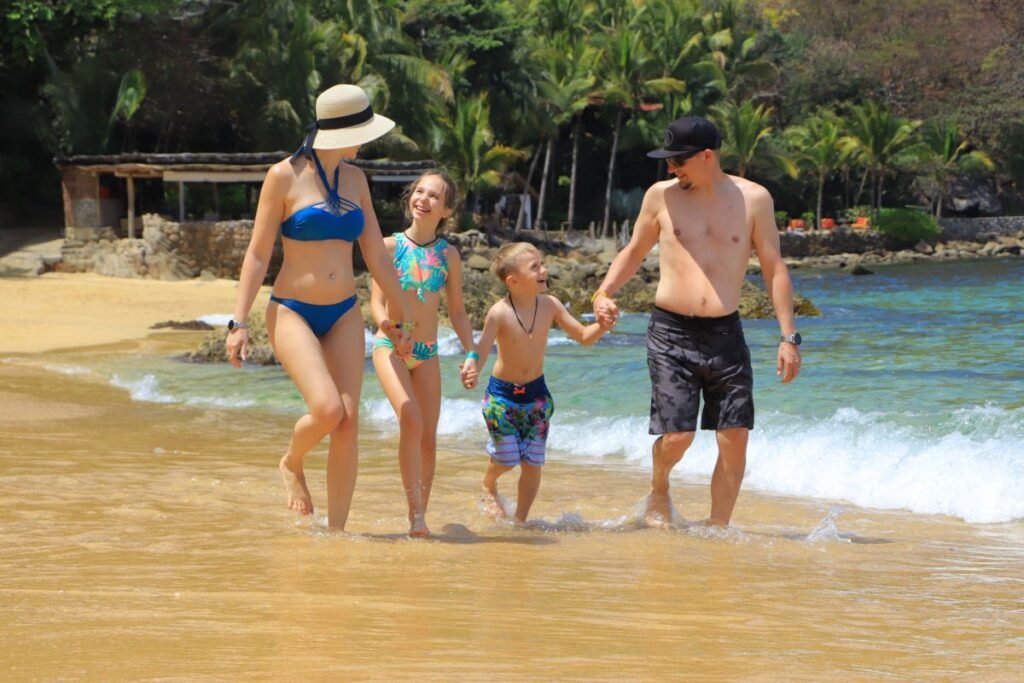 Familia caminando por la playa privada de Las Caletas.