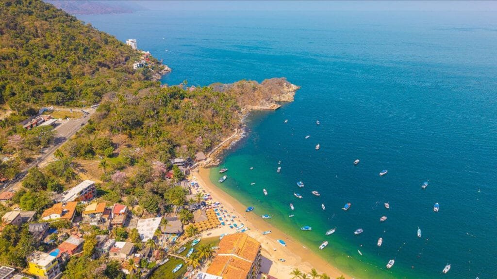 Toma aérea de gran altura mostrando la Playa Mismaloya y la infraestructura del nuevo muelle.