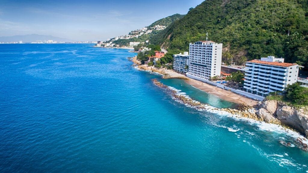 Panorámica del mar turquesa y la orilla rocosa frente al Costa Sur Resort Puerto Vallarta.
