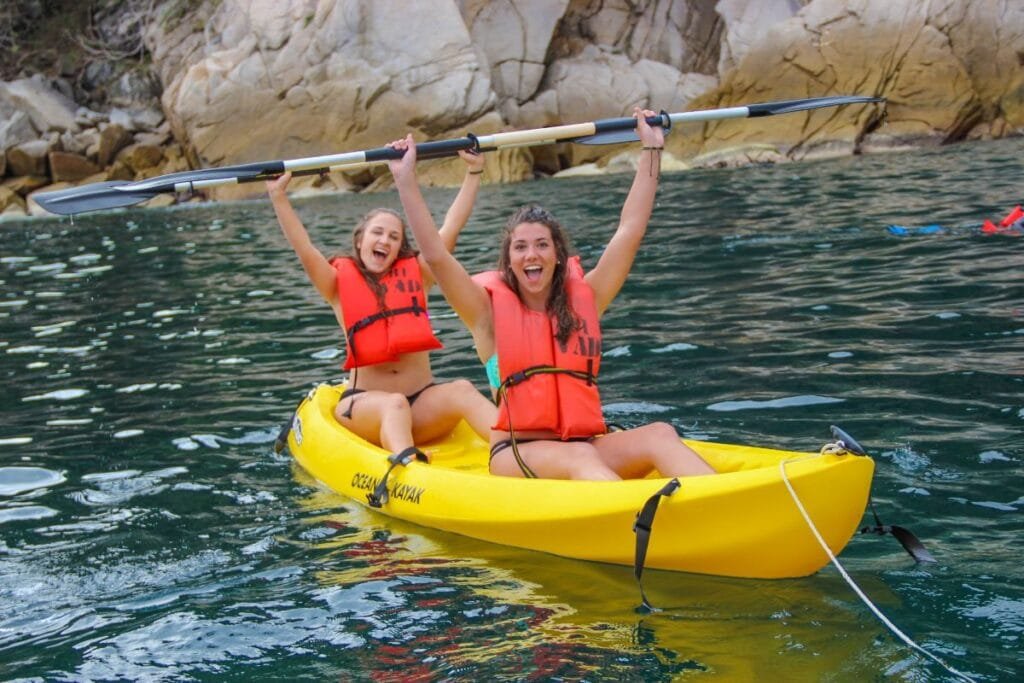 Dos mujeres felices remando en kayak durante la excursión Cascada Yelapa & Majahuitas Beach BBQ.