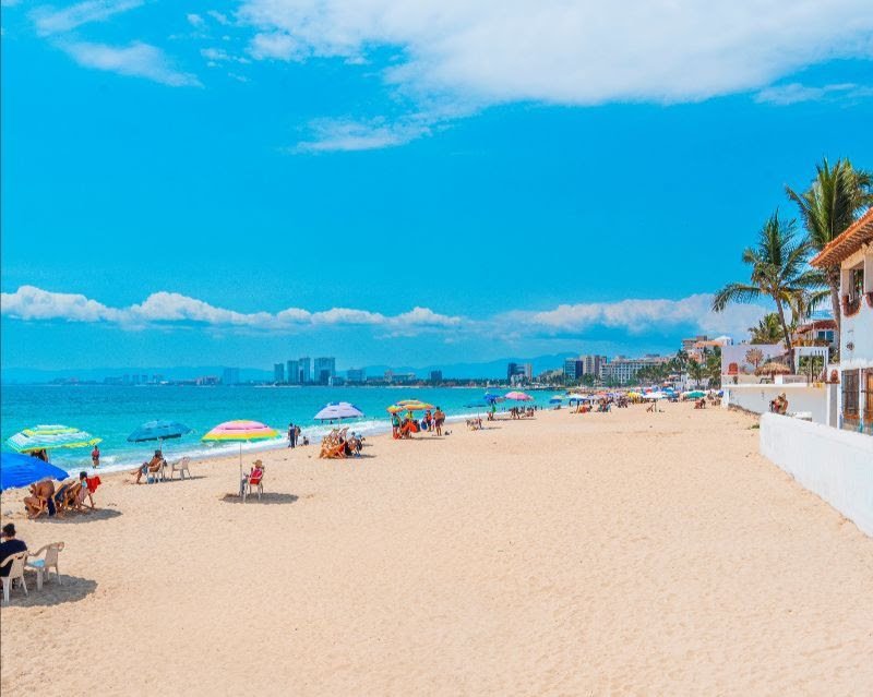 Turistas disfrutando de la Semana Santa en Puerto Vallarta en playas de arena dorada.