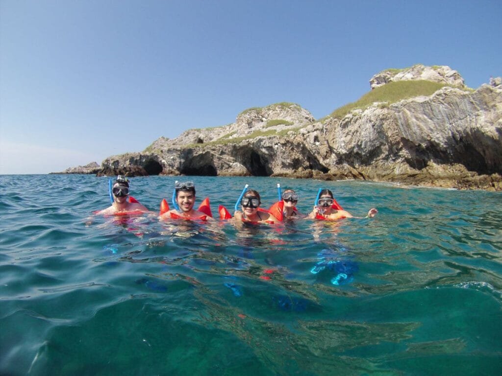 Turistas haciendo snorkel con guías expertos en Islas Marietas.