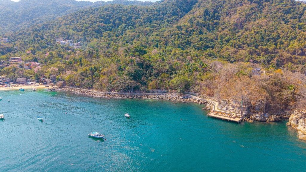Lanchas turísticas navegando junto al Muelle de Mismaloya en Jalisco, facilitando la conexión náutica.