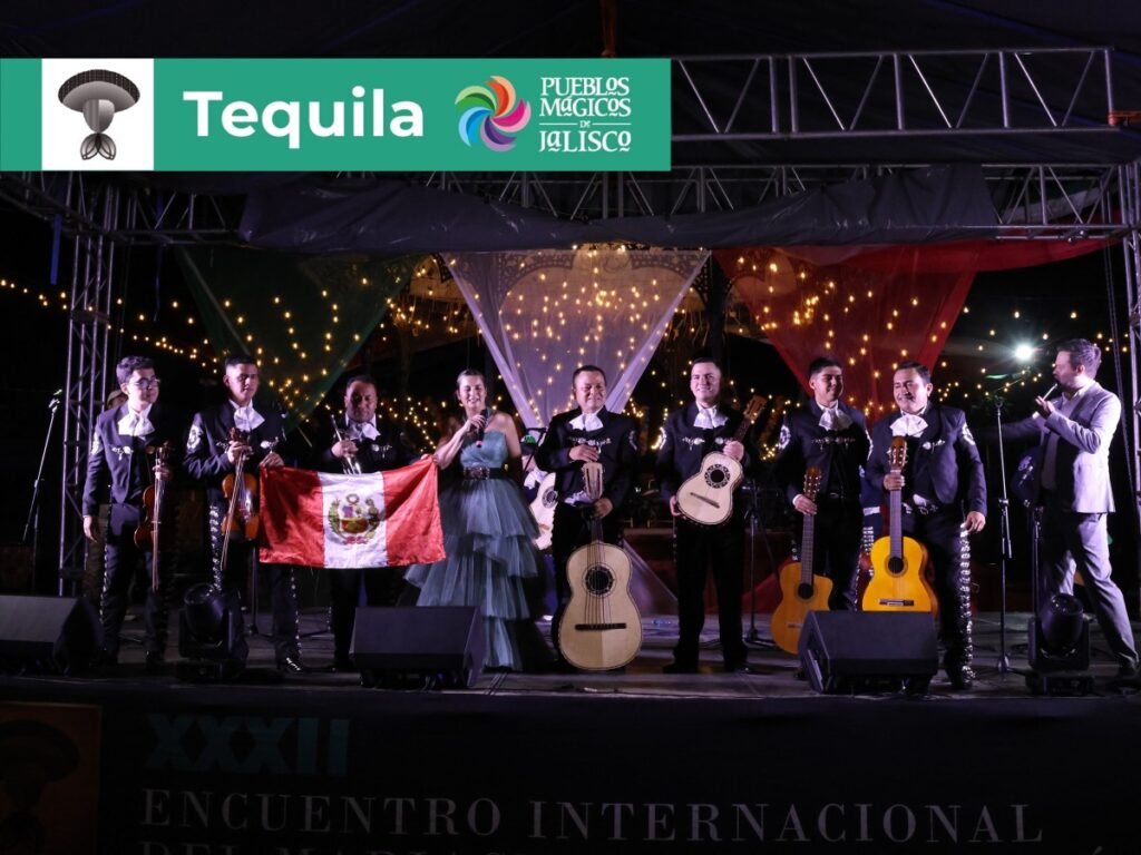 Encuentro Internacional del Mariachi y la Charrería 2026: Sedes 10 Ensamble de mariachi internacional con bandera de Perú presentándose en la plaza del Pueblo Mágico de Tequila durante el festival de Jalisco.