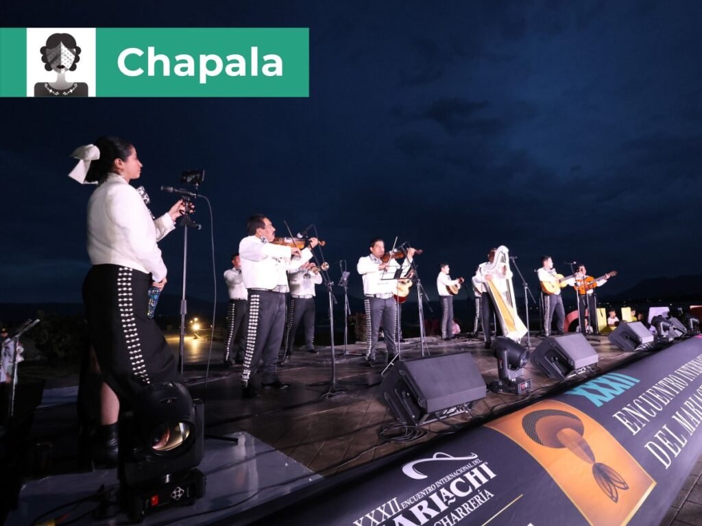 Encuentro Internacional del Mariachi y la Charrería 2026: Sedes 11 Concierto al aire libre de mariachi con arpista y cantante solista en el malecón de Chapala al anochecer frente al lago más grande de México.