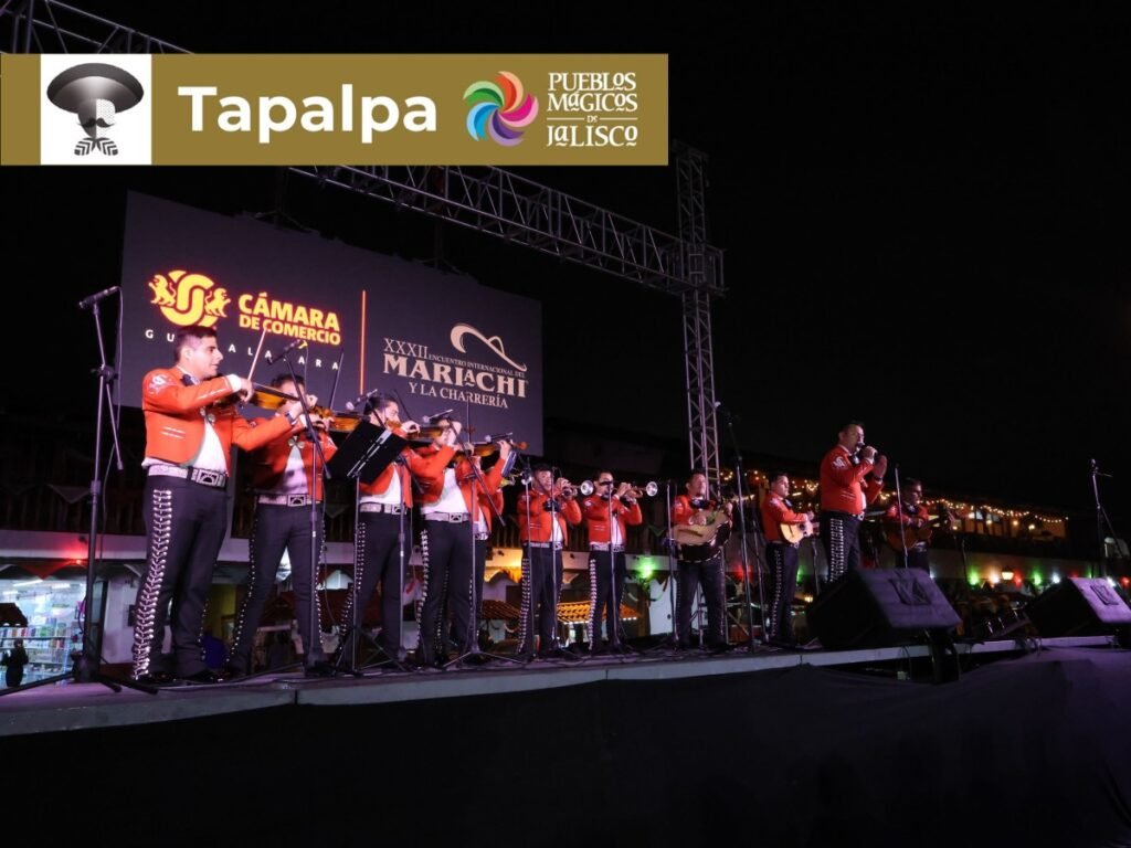 Encuentro Internacional del Mariachi y la Charrería 2026: Sedes 8 Concierto al aire libre de mariachi en trajes naranja sobre templete en la plaza del Pueblo Mágico de montaña de Tapalpa, Jalisco.