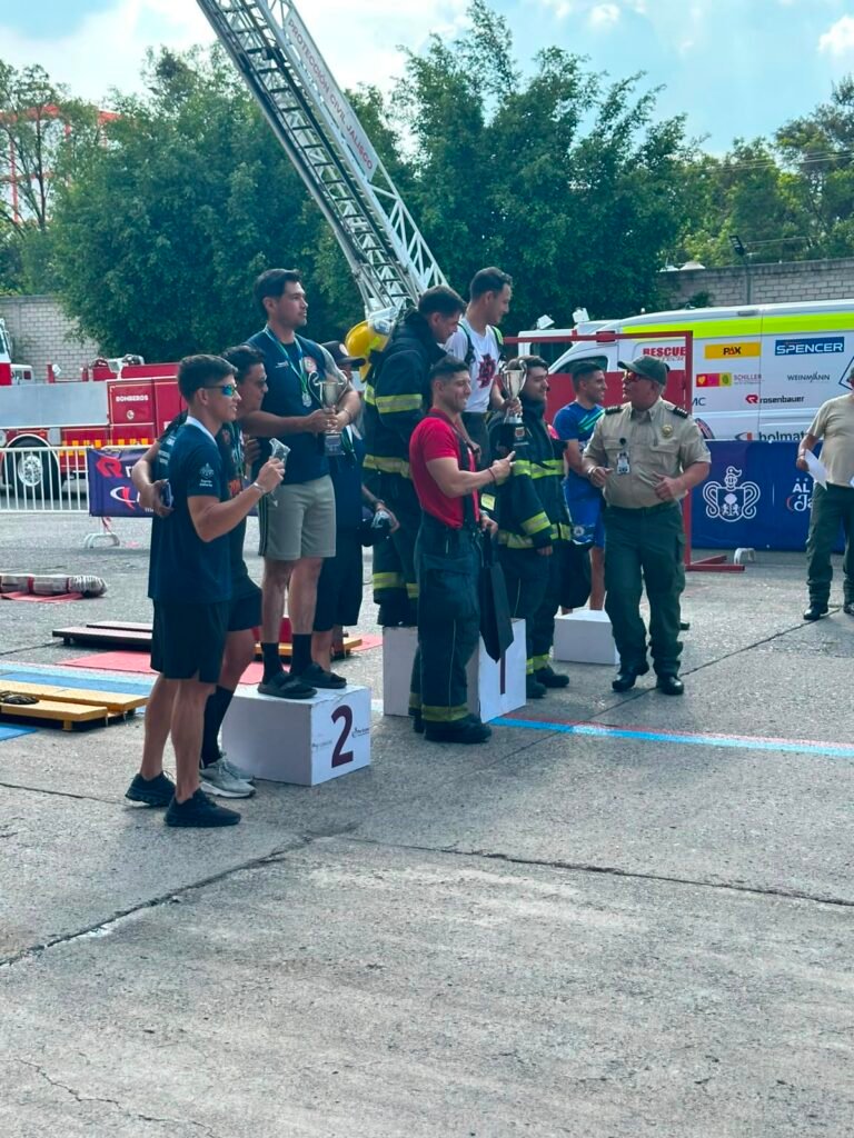 Bomberos Puerto Vallarta Triunfan en Copa Jalisco 2026 1 Momento de la premiación sobre el podio en la competencia estatal de bomberos con autoridades de Protección Civil Jalisco entregando trofeos.
