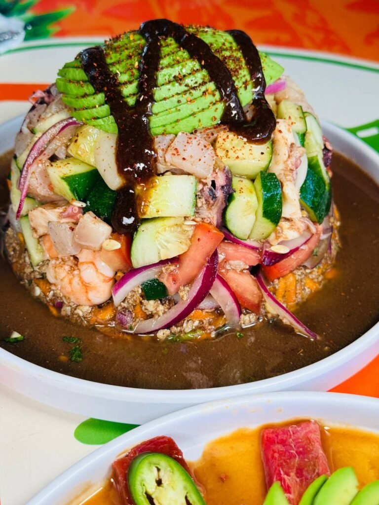 Mariscos Vida Mar Puerto Vallarta: Frescura Colosal y Sabor a Fuego 3 Tostada del mar con volumen esférico repleta de camarón, pulpo y callito fresco bañada en salsa secreta.