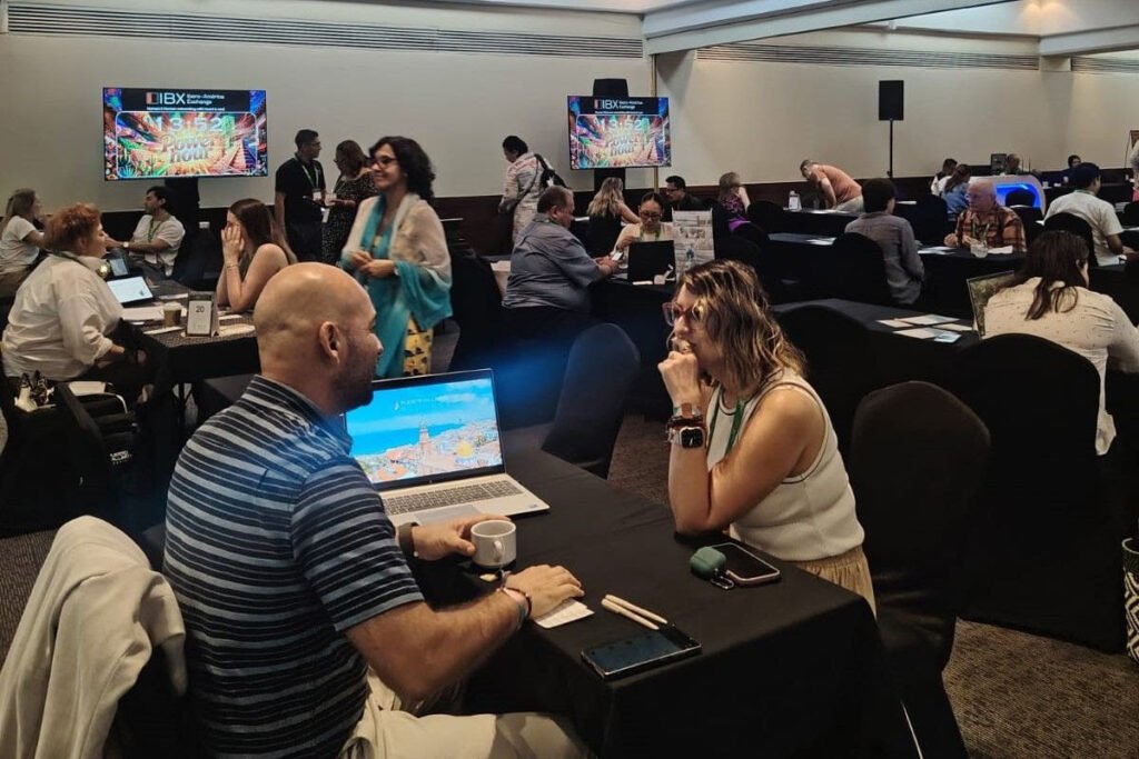 Pareja de profesionales del turismo charlando frente a una computadora durante una sesión de vinculación.