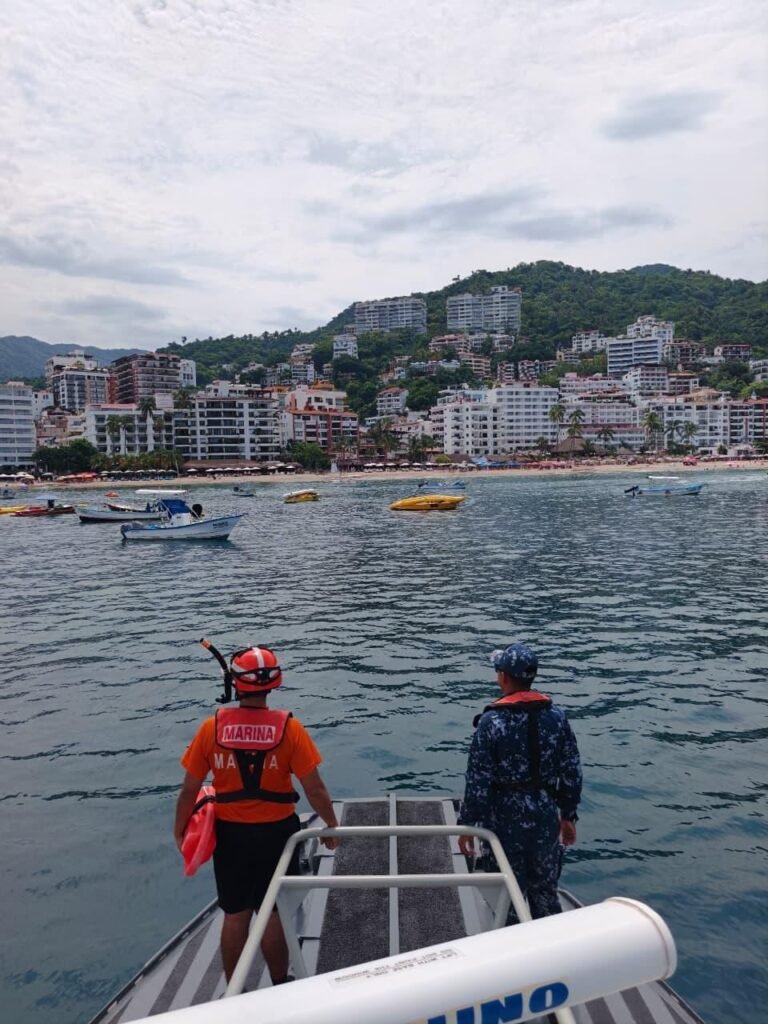 Operación Salvavidas Verano 2026: Éxito Total en Playas 3 Rescatistas acuáticos de la ENSAR Vallarta navegando en aguas costeras de la bahía con vista a la cordillera y hoteles de Puerto Vallarta.