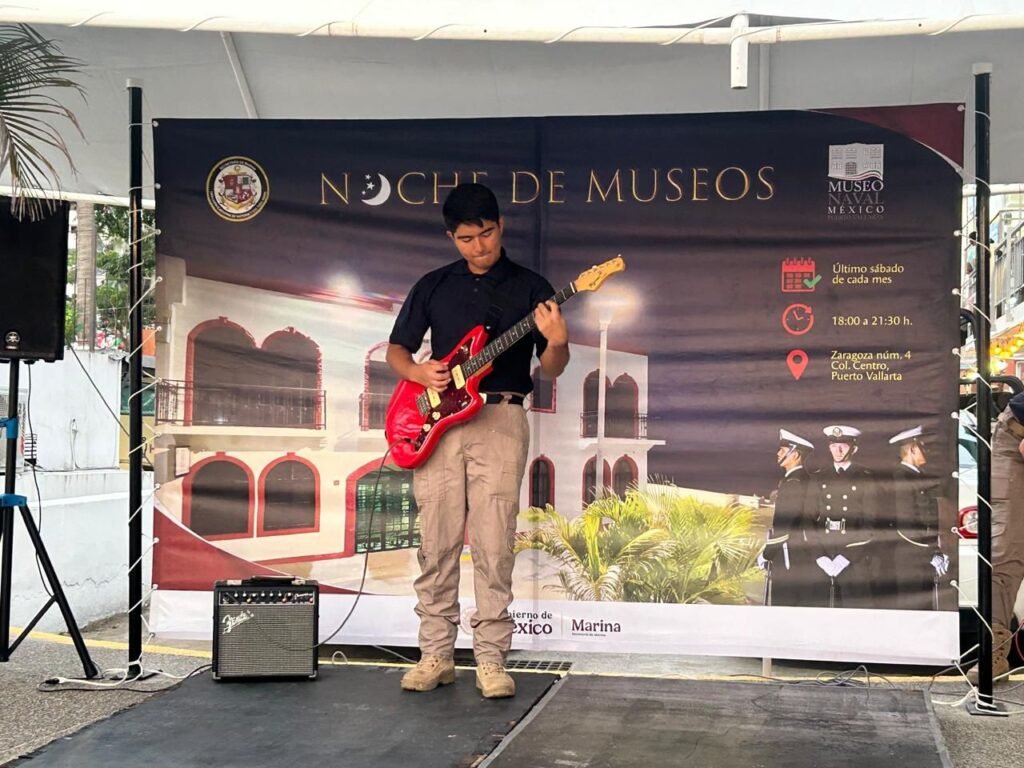 Noche de Museos Puerto Vallarta: Éxito Cultural Increíble 6 Estudiante naval participando con su guitarra en el escenario de la Noche de Museos.