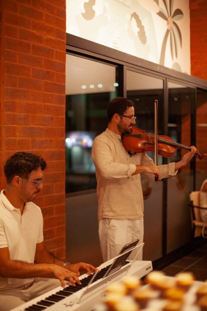 Dúo musical de violín y piano eléctrico interpretando melodías durante la inauguración de Natisa en Plaza San Marino Fluvial.