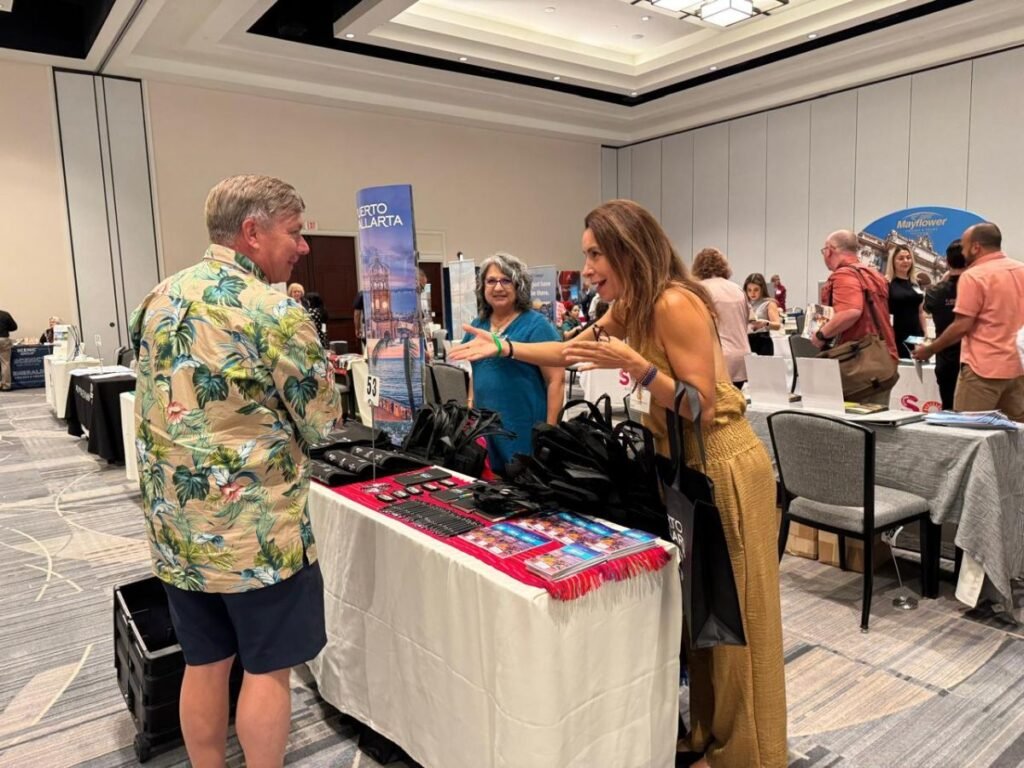 Representante de turismo de Jalisco conversando con un agente de viajes sobre vuelos directos a Puerto Vallarta.