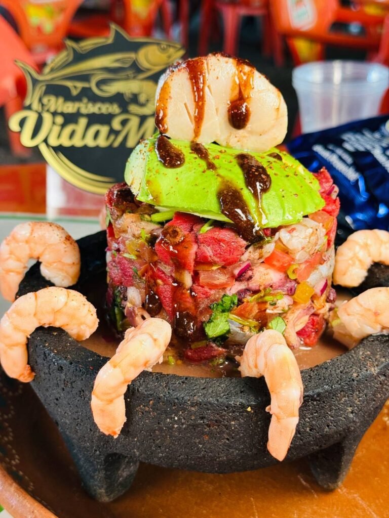 Mariscos Vida Mar Puerto Vallarta: Frescura Colosal y Sabor a Fuego 5 Torre Traviesa de mariscos frescos servida en un molcajete tradicional de piedra volcánica para compartir.