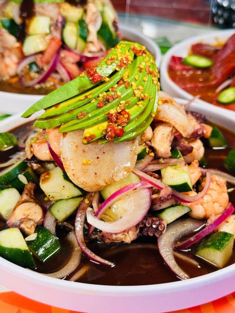 Mariscos Vida Mar Puerto Vallarta: Frescura Colosal y Sabor a Fuego 4 Tostada Pepona con callo de hacha fresco y reducción densa de salsa de chiltepín oscuro tostado.